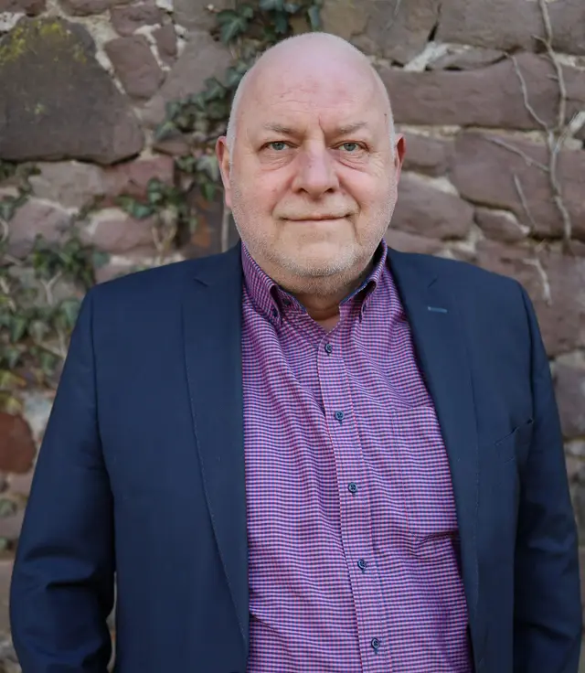 Holger Borchert vor einer Bruchsteinmauer